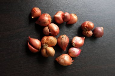  Taze kırmızı soğan ya da soğan siyah ahşap bir masada. Tayland yemeği ve Tayland otları, baharatlar. 