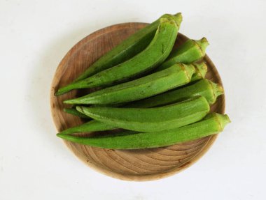Genç çiğ bamya, bayanların parmağı, gombo, gumbo, bendee, quimbamto (hisbicus esculentus l.) Tahta tabakta yatıyordu.