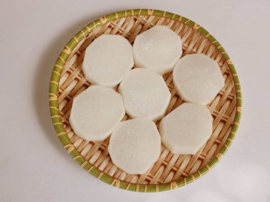  beyaz daikon, daikon turp, beyaz turp (raphanus sativus var. Longipinatus) Ahşap trayonda beyaz bir arka planda yatıyordu.