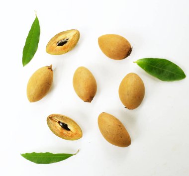 Yarı kesilmiş ve yeşil yapraklı bir grup taze organik tatlı meyve, sapodilla eriği, sapota (l) p. royen), sapodilla, sawo beyaz zemin üzerinde izole edilmiş.