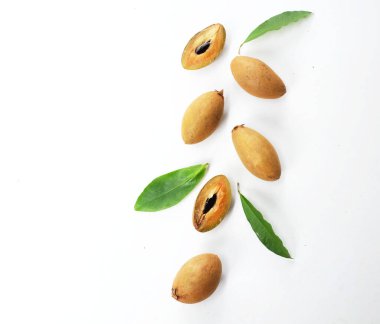 Yarı kesilmiş ve yeşil yapraklı bir grup taze organik tatlı meyve, sapodilla eriği, sapota (l) p. royen), sapodilla, sawo beyaz zemin üzerinde izole edilmiş.