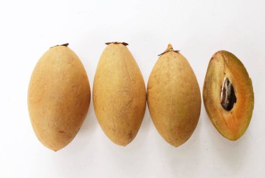 Yarı kesilmiş ve yeşil yapraklı bir grup taze organik tatlı meyve, sapodilla eriği, sapota (l) p. royen), sapodilla, sawo beyaz zemin üzerinde izole edilmiş.