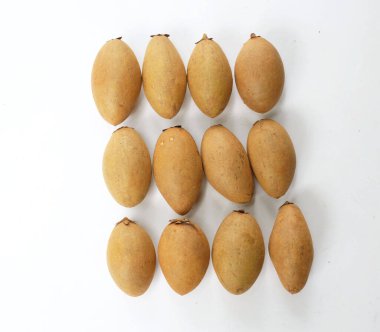 Yarı kesilmiş ve yeşil yapraklı bir grup taze organik tatlı meyve, sapodilla eriği, sapota (l) p. royen), sapodilla, sawo beyaz zemin üzerinde izole edilmiş.