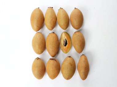 Yarı kesilmiş ve yeşil yapraklı bir grup taze organik tatlı meyve, sapodilla eriği, sapota (l) p. royen), sapodilla, sawo beyaz zemin üzerinde izole edilmiş.