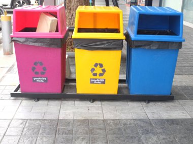 Yeşil parktaki ayrı plastik, kağıt ve organik çöp toplama için mavi, sarı ve yeşil konteynır. Temizlik ve atık geri dönüşümü kavramları