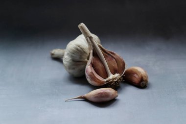 Bir diş sarımsak ve bir kafa mutfakta masanın üzerinde yatıyor.