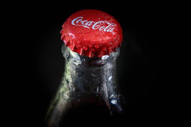 Siyah arka planda bir şişe ıslak kola.