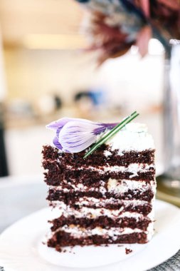 Vejetaryen çikolatalı kek. Mutfakta çiçeklerle. Yaklaş, ön manzara. Yumuşak seçici odak. 