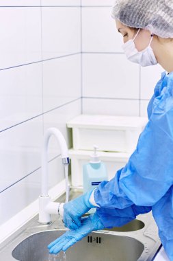 Doktor musluğun altında sabun ve ellerini yıka. Hijyen konsepti el detayı.