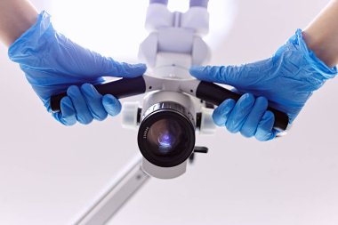 Aşağıdan bak. Mikroskop. Laboratuvar ekipmanları. Ellerinde mikroskop var.. 