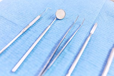 Mavi arka planda dişçi aletleri. Enstrümanların sterilizasyonu.