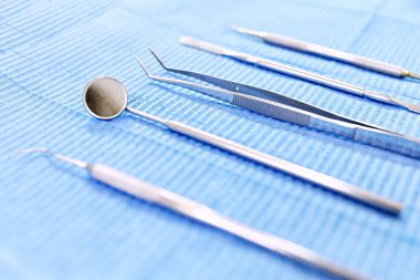 Mavi arka planda dişçi aletleri. Enstrümanların sterilizasyonu.