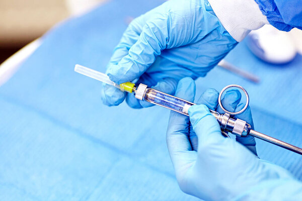 Medic hands in protective gloves with anaesthesia syringe.  Dental anaesthesia. 
