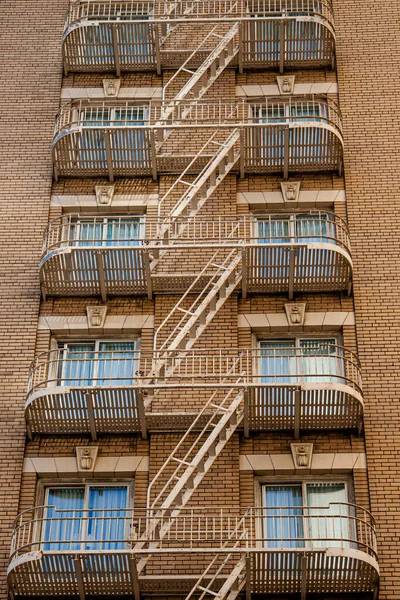 Windows, brick walls and fire escapes of an American apartment block