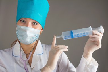 Kadın doktor işlem için hazırlar. Doktor yorgun. Bir iğne için.