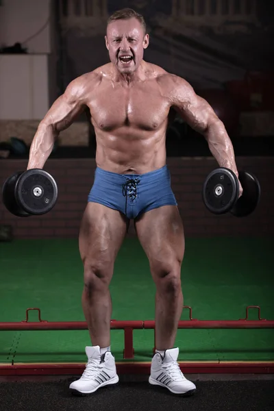 Bir Adam Spor Salonuna Gider Kaslarını Çalıştırır Vücut Geliştirici Halterlerle — Stok fotoğraf