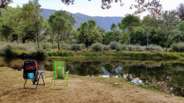 Nehrin yanında bir çift boş plaj sandalyesi. Tera Nehri, Ribadelago Viejo Köyü, Sanabria Doğal Parkı, Zamora, İspanya