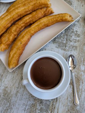 A plate of porras, similar to churros, and a cup of hot chocolate, a typical breakfast in Madrid and many parts of Spain.
