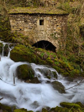 Belmonte de Miranda, Asturias, İspanya 'da bir şelalenin yanında eski bir taş fabrikası.