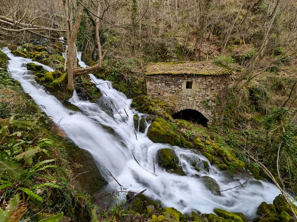 Belmonte de Miranda, Asturias, İspanya 'da bir şelalenin yanında eski bir taş fabrikası.