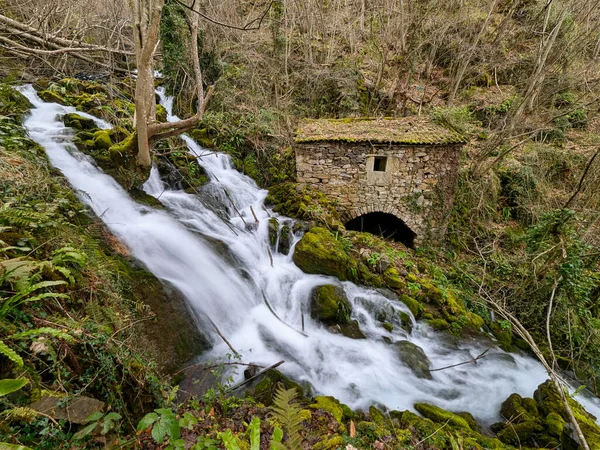 Belmonte de Miranda, Asturias, İspanya 'da bir şelalenin yanında eski bir taş fabrikası.