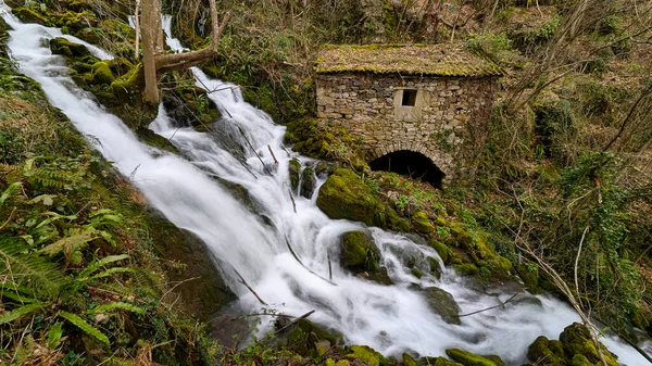 Belmonte de Miranda, Asturias, İspanya 'da bir şelalenin yanında eski bir taş fabrikası.
