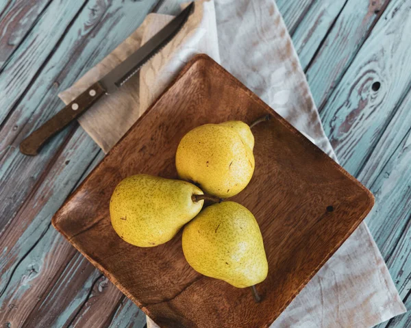 still life, three pears on a wooden plate in rustic style