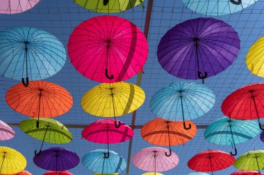 Güneş gölgesi gibi renkli şemsiyeler, farklı renklerdeki şemsiyelerin renkli arkaplanı