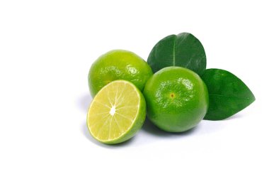 Toplanan taze yeşil çiğ limon ve yaprakların yakın plan çekimleri beyaz arka planda izole edilmiş.