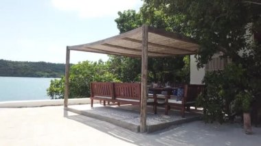 Bir cennet adasında kumsal dekorasyonu fikri, yemek masası, sandalyeler ve oturma odası.