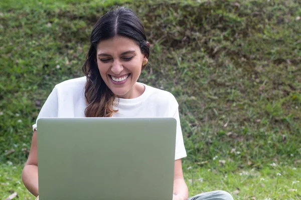 latina woman smiling at laptop in an online class. Fresh Air
