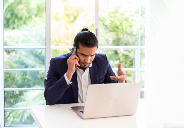 Ofis masasında oturan ciddi Latin iş adamı. Yeni normal