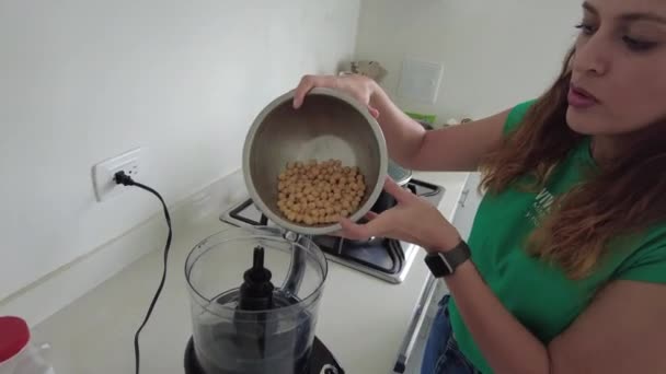 Kvinna sätta kikärter i matberedaren — Stockvideo