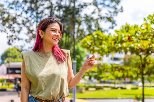 young latina student smiling on campus looking at her right