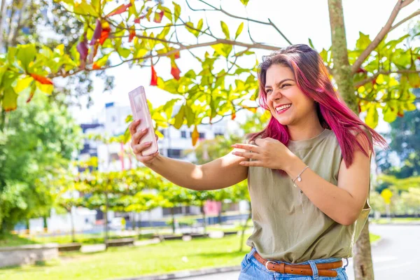 young latina woman recording a story for her social networks