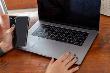 Ofis bilgisayarındaki bir masanın üstündeki bir iş yerine ve masadaki cep telefonuna yakın çekim