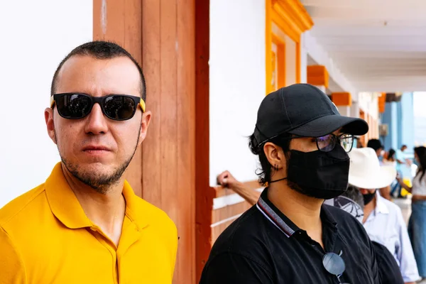 Hommes avec et sans masque debout près du bâtiment — Photo