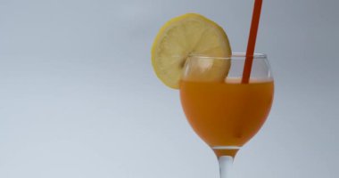 Limonlu ve samanlı bir bardak portakal suyu.