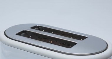 Kızarmış ekmek kızartma makinesinde yanıyor. Beyaz tost makinesinden fırlayan kızarmış ekmek.