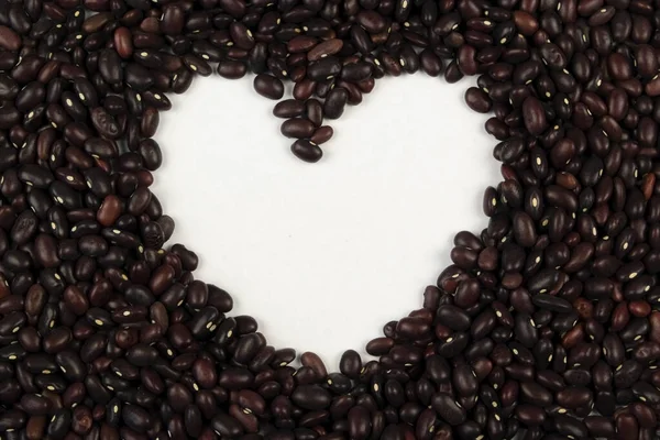 Beyaz arka planda fasulyeden yapılmış bir kalp..