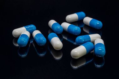 Mavi ve beyaz kapsüller aşağıdan yansıtılır.