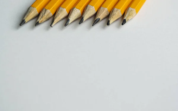 Keskin kalemlerin uçları beyaz arka planda üstte..