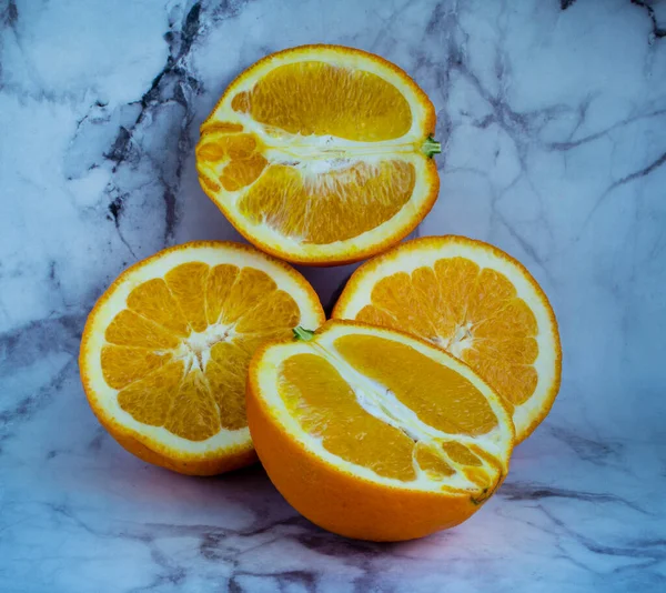 Bir mermer zeminde dört turuncu yarım.