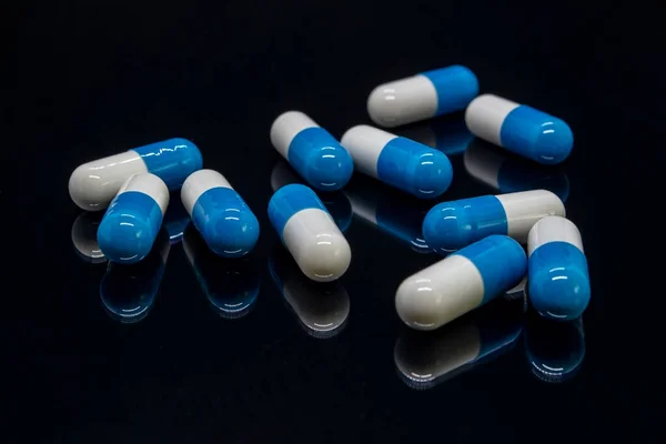 Mavi ve beyaz kapsüller aşağıdan yansıtılır.