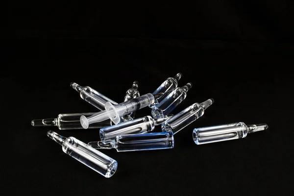 Siyah zemin üzerinde şırınga olan dağınık ampuller.