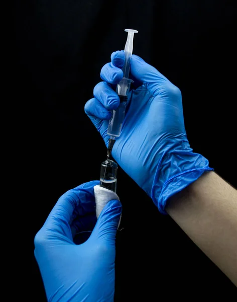 Doktor şırınganın içine serumu çeviriyor..