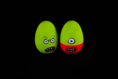 Kızgın yüzlü iki yeşil oyuncak yumurta..