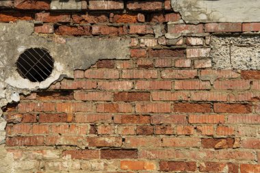 Yuvarlak havalandırmalı eski bir tuğla duvar..