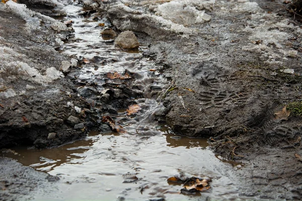 Erimiş kardan bir bahar nehri ve bir bot izi..