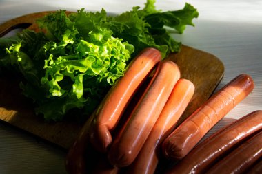 Kesme tahtasında sosisli yeşil salata..